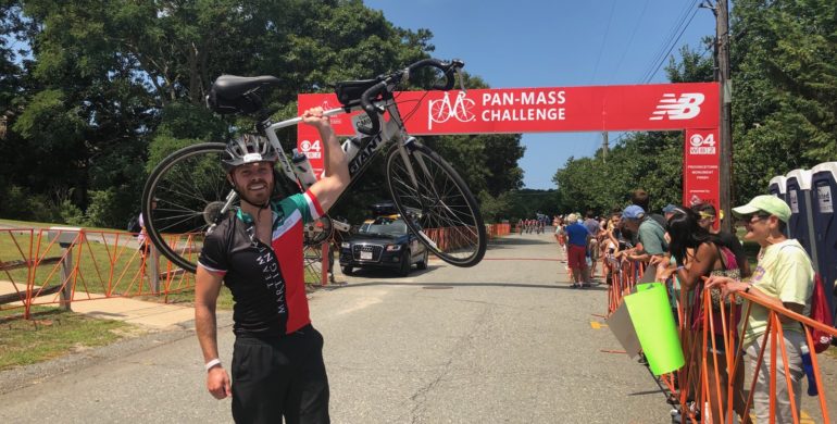 image of man holding a bike at pan-mass challenge